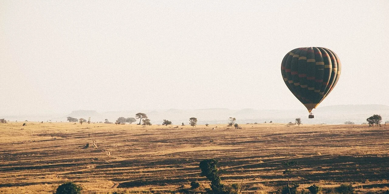 A hot-air balloon above open grassland in the Serengeti